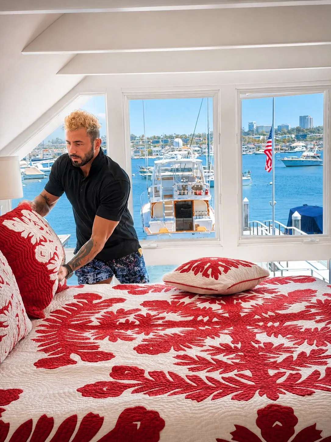 Paul making the bed in a Newport Beach waterfront bedroom overlooking the harbor